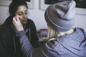 Ein Moment der Vorbereitung, während eine Freundin vor der standesamtlichen Trauung sanft Make-up aufträgt.