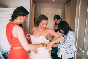 Drei Frauen helfen der Braut beim Anziehen ihres Kleides – echte Momente, Hochzeitsfotografin Köln.