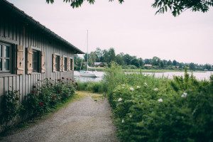Sonniger Weg am Holzhaus mit Blick auf den See – natürliche Hochzeitsreportage NRW.