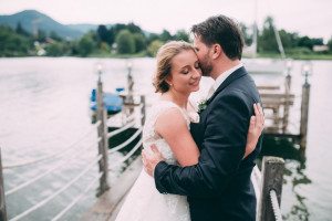 Braut und Bräutigam verbringen einen ruhigen Moment auf einem Steg am Seeufer, festgehalten von der Hochzeitsfotografin Köln.