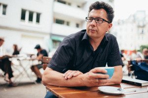 Mann genießt Kaffee im Kölner Straßencafé – natürliche Momentaufnahme für Hochzeitsreportage NRW.