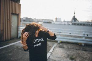 Portrait einer Frau auf einem Kölner Dach, entspannt bei Wind – Hochzeitsfotografin Köln Moment.