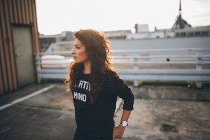 Warmes Sonnenlicht über Köln: Frau mit lockigem Haar lächelt auf einem Dach, Hochzeitsfotografin-Portrait.
