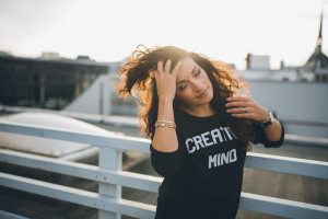 Frau mit langen Locken auf Kölner Dach, entspannt beim Outdoor-Portrait – Hochzeitsfotografin Köln.