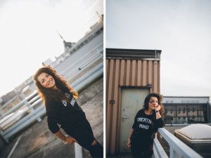 Warmes Sonnenlicht auf einer lockigen Frau, die auf einem Kölner Dach lächelt – authentische Portraitfotos Outdoor.