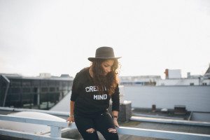 Junge Frau mit schwarzem Hut genießt entspannte Momente am Rhein in Köln – Hochzeitsfotografin Köln.