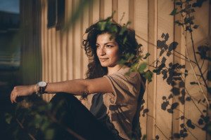 Die Braut sitzt im sanften Sonnenlicht, die Schatten der Blätter tanzen – entspanntes Porträt von der Hochzeitsfotografin Köln.