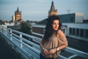 Braut mit lockigen Haaren auf Kölner Rooftop bei Sonnenuntergang – Hochzeitsfotografin Köln.