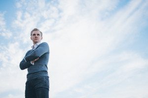 Bräutigam im grauen Pullover lächelt draußen nach standesamtlicher Trauung – Hochzeitsfotografin Köln.