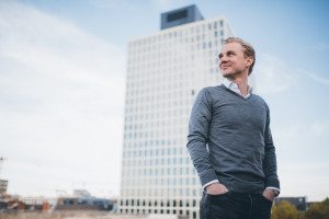 Lockeres Porträt eines Mannes vor moderner Architektur – Bewerbungsfotos Köln draußen.