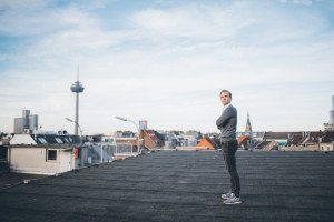 Bewerbungsfoto-Shooting auf dem Dach in Köln mit lockerer Pose und Blick über die Stadt.