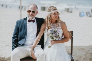 Brautpaar sitzt entspannt am Strand von Noordwijk – Hochzeitsfotografin Köln hält den Moment fest.