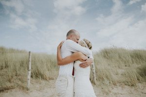 Brautpaar umarmt sich herzlich am Strand von Noordwijk – Hochzeitsreportage NRW.
