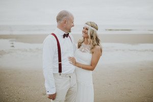 Brautpaar lächelt sich am Strand von Noordwijk an – Hochzeitsreportage NRW, natürliche Momente.