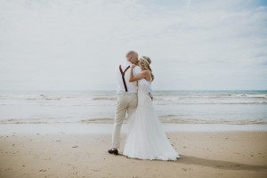 Brautpaar küsst sich am Strand von Noordwijk – natürliche Hochzeitsreportage NRW.