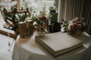 Hochzeitsalbum, Kamera, Blumen und Film auf einem Tisch – Vorbereitungen für eine Hochzeitsreportage NRW.