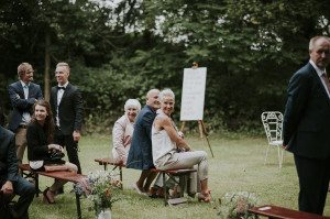 Hochzeitsgäste lachen entspannt im Grünen bei der standesamtlichen Trauung in Wasserburg Geretzhoven.