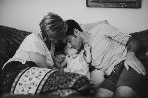 Warmer Familienmoment: Paar mit Baby auf dem Sofa in Köln, festgehalten von Hochzeitsfotografin Köln.