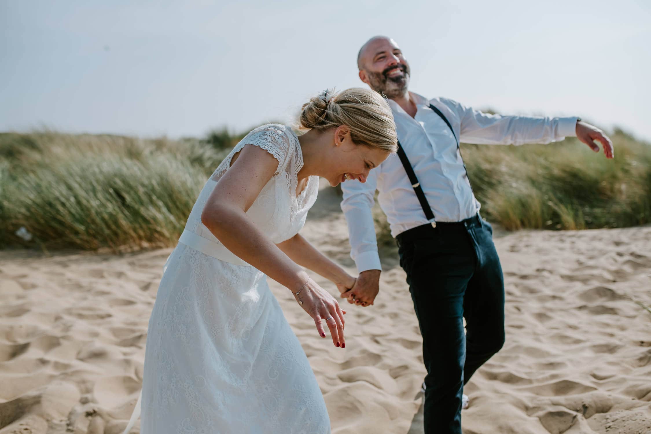 Lachendes Brautpaar bei Strandhochzeit in Noordwijk