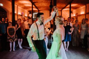 Brautpaar tanzt eng umschlungen bei ihrer Hochzeit im Gut Hohenholz, Gäste lächeln zu.
