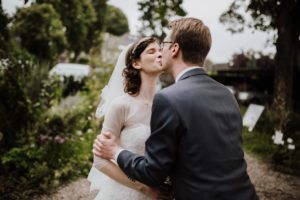 Brautpaar küsst sich draußen im Grünen – natürliche Hochzeitsreportage von Hochzeitsfotografin Köln.