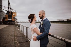 Brautpaar an der Kölner Rheinpromenade, authentisch festgehalten von Hochzeitsfotografin Köln.