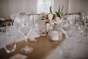 Liebevoll gedeckter Hochzeitstisch mit Blumen, Kerzen und Tischnummer – Hochzeitsreportage NRW.
