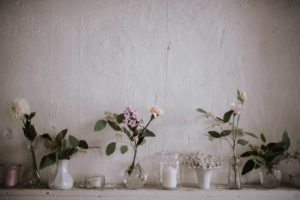 Zarte Blumen in kleinen Vasen auf einem Regal – natürliche Details für Hochzeitsreportage NRW.