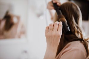 Braut stylt ihre Haare vor der standesamtlichen Trauung, festgehalten von Hochzeitsfotografin Köln.