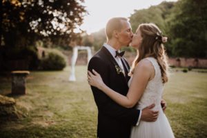 Brautpaar küsst sich im Abendlicht vor Schloss Föhren – Hochzeitsfotografin Köln hält den Moment fest.