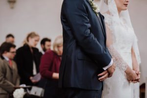Braut und Bräutigam bei ihrer standesamtlichen Trauung in Düsseldorf, umgeben von Familie und Freunden.