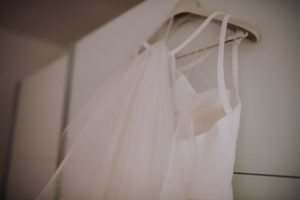 Elegantes Brautkleid mit Tüll an einem Bügel, festgehalten von Hochzeitsfotografin Köln am Hochzeitstag.