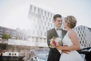 Brautpaar lächelt sich vor moderner Kulisse am Schokoladenmuseum Köln an – Hochzeitsfotografin Köln.