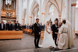 Brautpaar am Altar mit Gästen, liebevoll festgehalten von Hochzeitsfotografin Köln in der Kirche.
