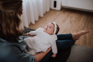 Eine Mutter auf dem Sofa hält liebevoll ihr Baby bei einer standesamtlichen Trauung in NRW.