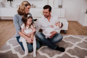 Familie lacht und spielt gemeinsam im Wohnzimmer – natürliche Hochzeitsreportage NRW.