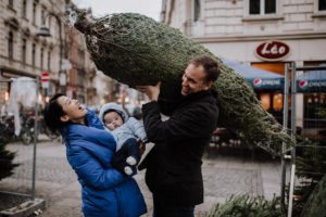 Ein Paar mit Baby kauft einen Weihnachtsbaum – natürliche, echte Hochzeitsreportage NRW.