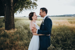 Brautpaar lächelt sich auf einer grünen Wiese an – Hochzeitsfotografin Köln hält den Moment fest.
