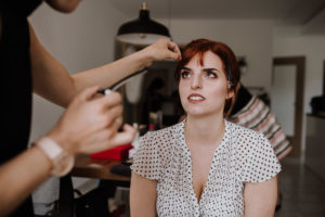 Eine Braut mit roten Haaren wird fürs Getting Ready liebevoll gestylt – Hochzeitsreportage NRW.