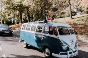 Brautpaar im Oldtimer-Bus küsst sich nach der standesamtlichen Trauung – Hochzeitsreportage NRW.