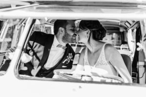Brautpaar lächelt sich im Auto an, festgehalten von Hochzeitsfotografin Köln bei der Trauung.