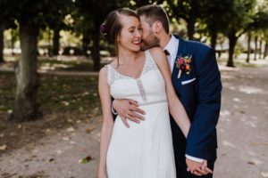 Braut und Bräutigam lachen herzlich auf einem Waldweg – natürliche Hochzeitsfotografie NRW.