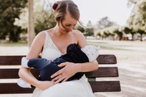 Mutter stillt ihr Baby im Park nach der standesamtlichen Trauung – echte Hochzeitsmomente Bonn.