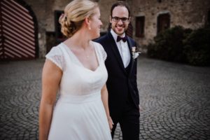 Brautpaar hält Händchen und lächelt sich an – natürliche Hochzeitsfotografie Köln am Hochzeitstag.