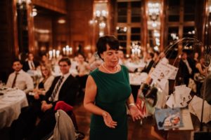 Eine Frau im grünen Kleid hält eine Rede bei warmem Kerzenschein – Hochzeitsreportage NRW.