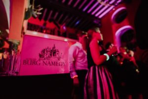 Freunde teilen einen freudigen Moment auf Schloss Burg Namedy – stimmungsvolle Hochzeitsreportage NRW.