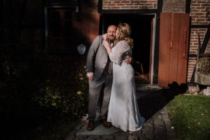 Braut im Spitzenkleid umarmt ihren Bräutigam an sonnigem Tag vor dem Standesamt Bonn – echte Hochzeitsreportage von Hochzeitsfotografin NRW.