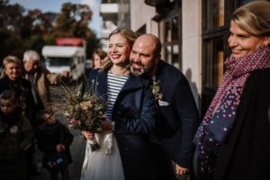 Ein entspanntes Hochzeitspaar in Bonn, umgeben von Freunden und Familie nach der standesamtlichen Trauung.
