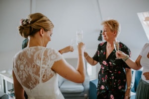 Freundinnen und Braut stoßen im Sonnenlicht an – echte Momente von Ihrer Hochzeitsfotografin Köln.
