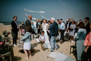 Herzlicher Moment, als eine Braut bei einer Strandhochzeit mit ihrem Vater zum Altar schreitet – Hochzeitsfotografin Köln.